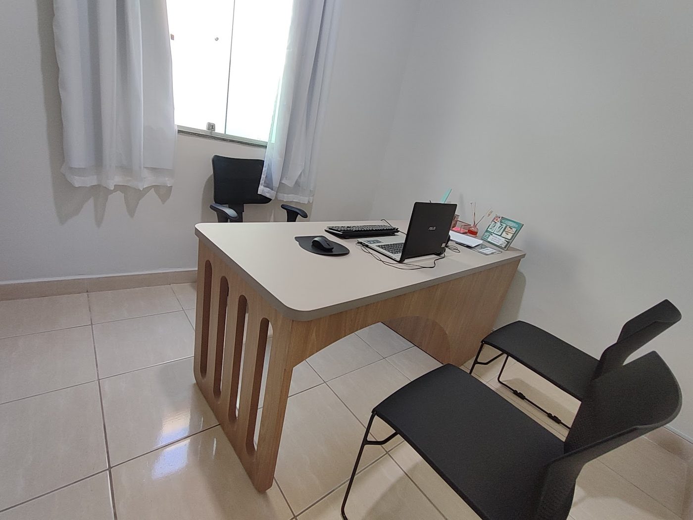 Mesa de escritório planejada em madeira clara com detalhe vazado